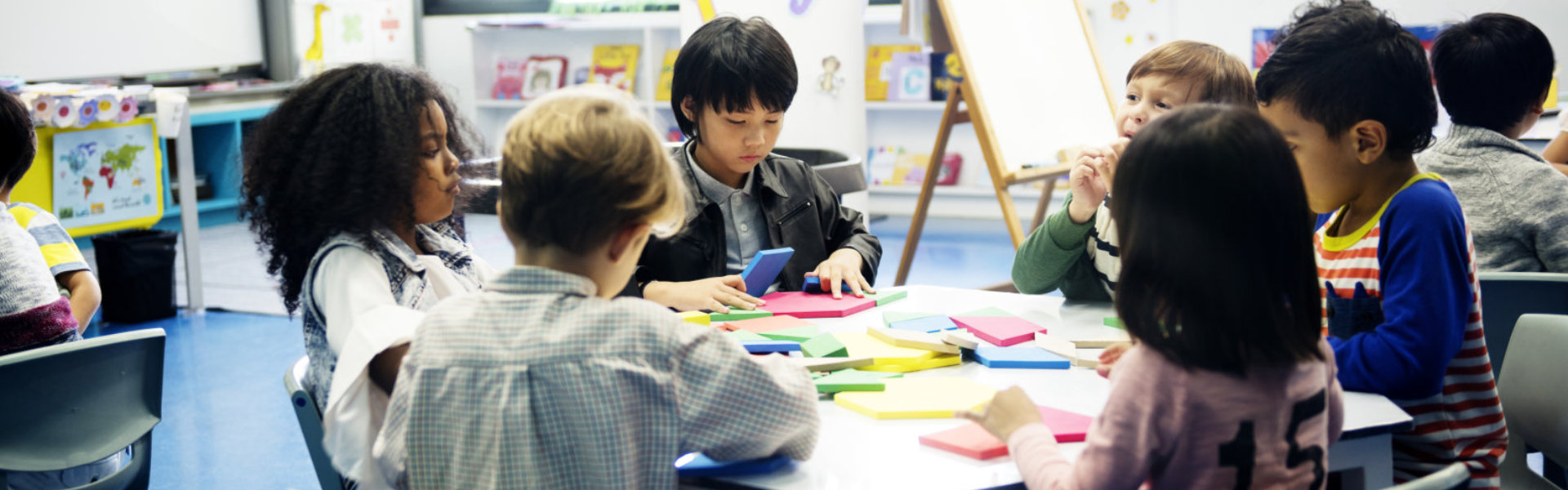 Group of diverse students at daycare sitting drawing