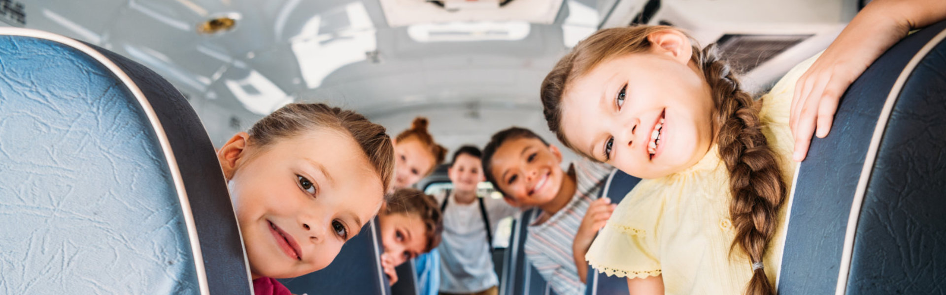 group of cute schoolchildren riding on school bus